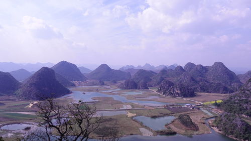 Scenic view of river by mountains against sky