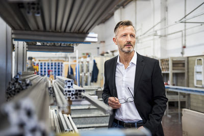 Mature businessman in factory thinking