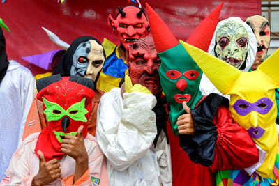 Group of people dressed in horror costumes against red background 