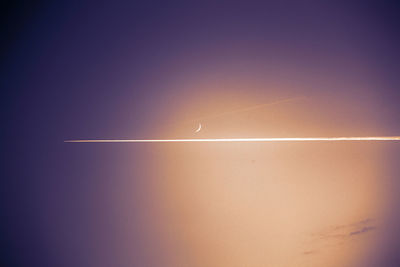 Low angle view of vapor trails in sky at night