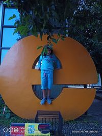 Full length of boy standing by tree in playground