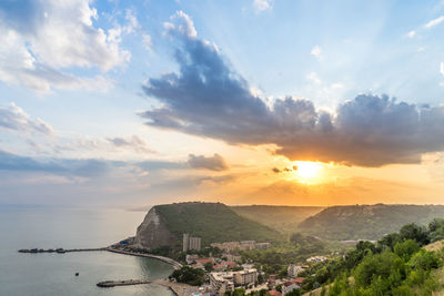 Scenic view of sea and buildings against sky during sunset