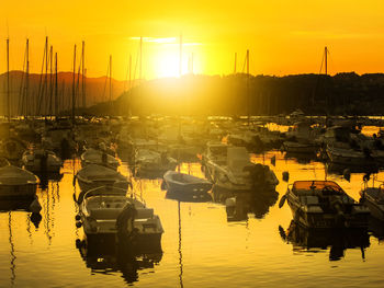 Boats moored in marina at sunset