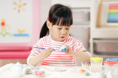 Cute girl sitting on table at home
