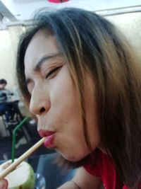 Close-up portrait of a beautiful young woman drinking water