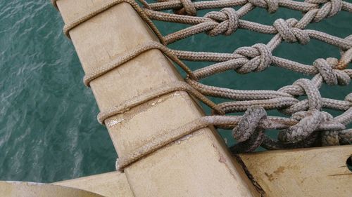 High angle view of rope tied to bollard at harbor