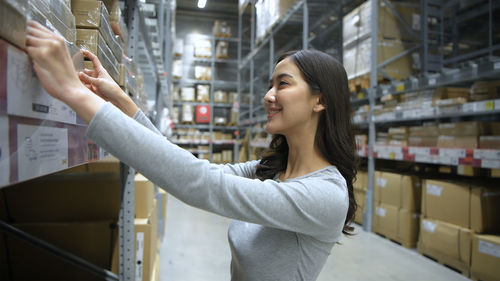 Side view of young woman looking away at store