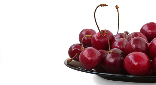 Close-up of cherries in bowl against white background