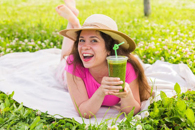 Young woman wearing hat while standing on plants