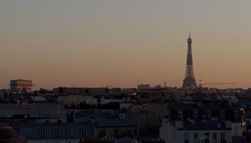 Buildings in city against sky during sunset