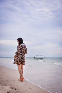 Rear view of woman looking at sea against sky