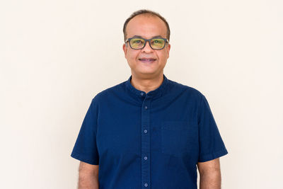 Portrait of smiling man standing against white background