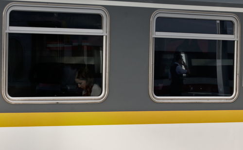 Train at railroad station platform seen through window