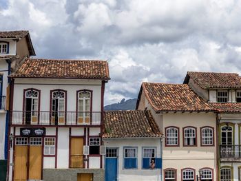 Low angle view of buildings in town against cloudy sky