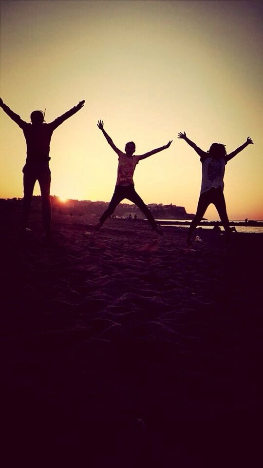 lifestyles, silhouette, full length, leisure activity, clear sky, sunset, copy space, standing, men, jumping, mid-air, low angle view, sky, person, outdoors, togetherness, arms raised