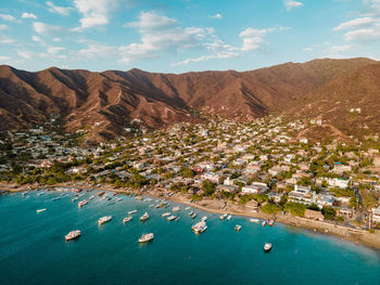 High angle view of townscape by sea against mountain