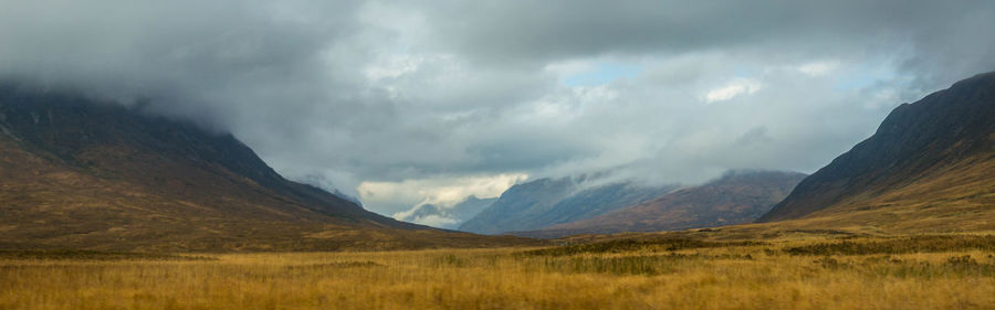 Scenic view of mountains against cloudy sky