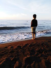 Rear view of man standing on beach