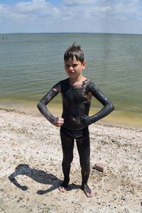 Boy covered in mud on  beach