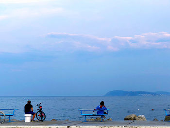 People on sea against sky