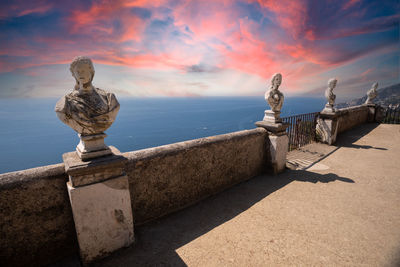 Statue by sea against sky during sunset