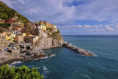 Scenic view of sea by buildings against sky