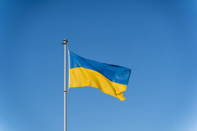 Ukrainian flag of yellow-blue colors on the background of clear blue sky