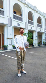 Portrait of man standing against building