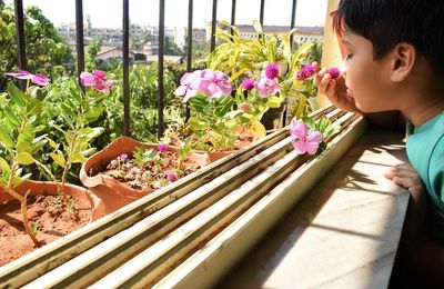 Side view of girl with flower petals on plants