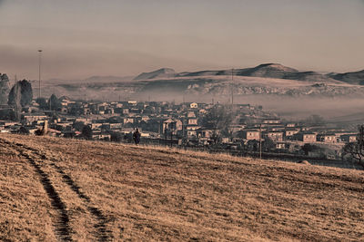 Town by buildings in city against sky