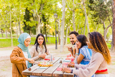 Cheerful friends having food outdoors