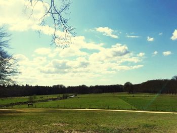 Scenic view of field against cloudy sky