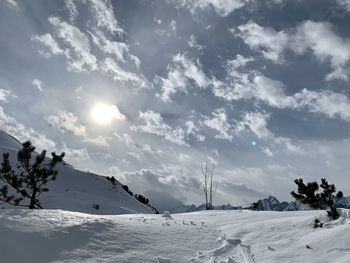 Snow covered landscape against sky