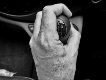 Close-up of hand holding gearstick in car