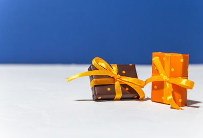 Close-up of yellow flag on table against blue background