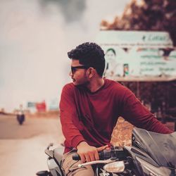 Side view of young man sitting on a motorcycle 
