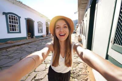 Tourist girl takes selfie in the historic colonial village tiradentes in minas gerais, brazil