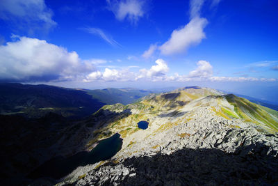 Scenic view of mountains against blue sky