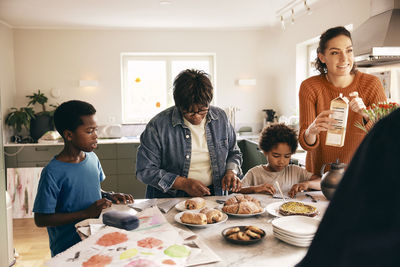 Family helping each other while preparing breakfast on kitchen island at home