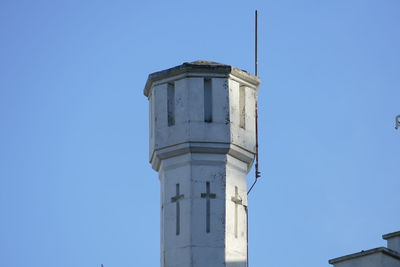 Low angle view of water tower against clear blue sky