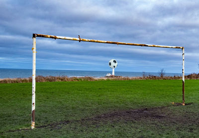 Wind turbines on field against cloudy sky