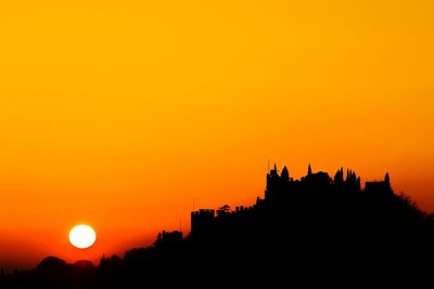 Silhouette of buildings against orange sky