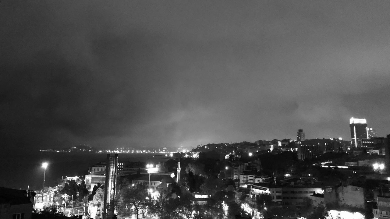 HIGH ANGLE VIEW OF ILLUMINATED CITY AGAINST SKY