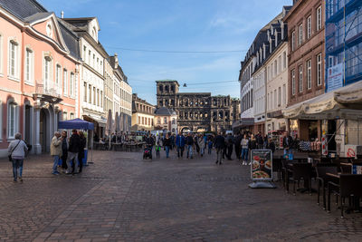 People walking on street amidst buildings in city