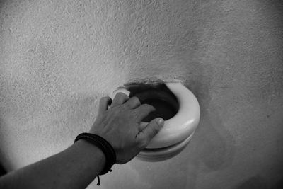 Close-up of hand holding hands against wall