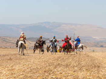 Group of people riding horses on land