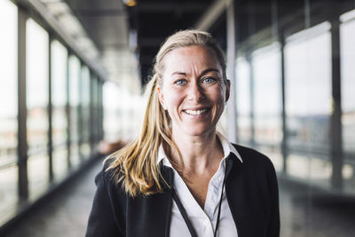 Portrait of smiling businesswoman standing in office