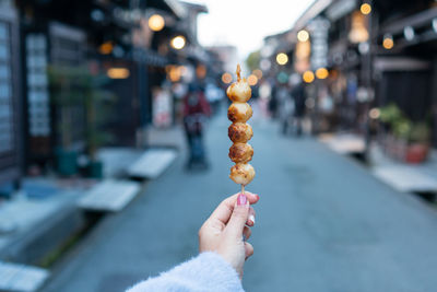 Cropped hand of woman holding food on street