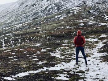 Rear view of man standing on snow