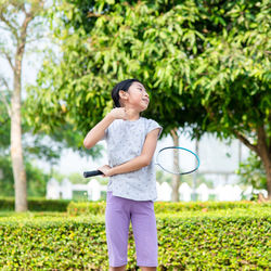 Full length of girl standing by plants